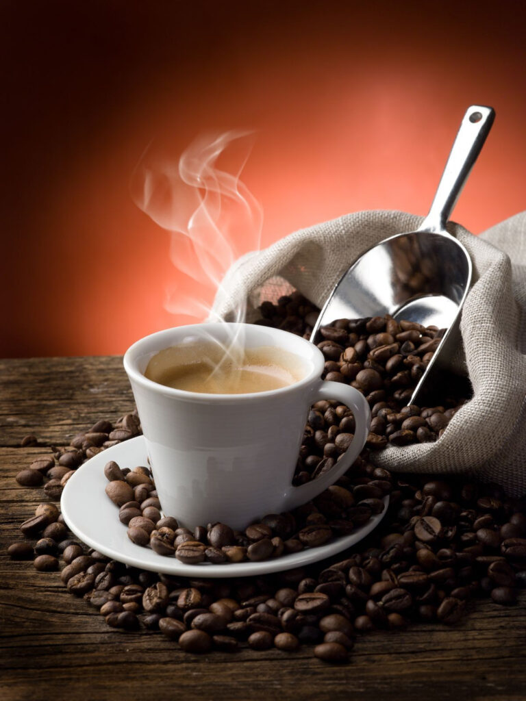 Tazza di caffè con vapore e chicchi di caffè Tazza di caffè con vapore e chicchi di caffè