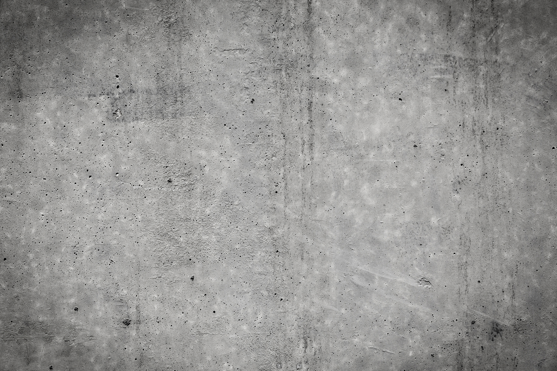 Grey concrete wall with black spots