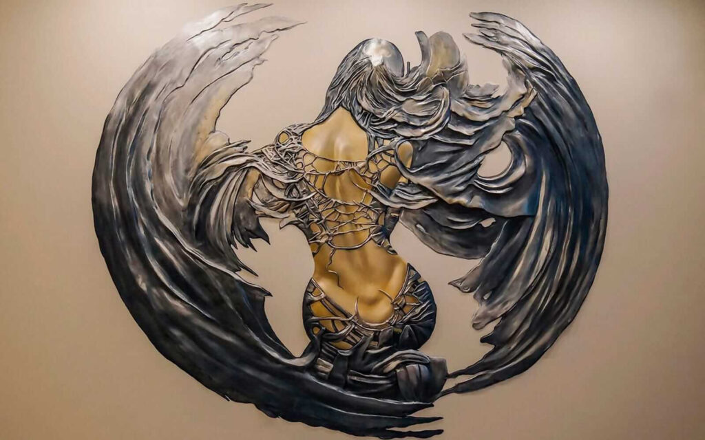 Scultura in metallo di una donna con le ali Scultura in metallo di una donna con le ali