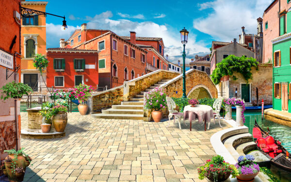 Patio con tavolo e sedie e fontana di fronte a un edificio Patio con tavolo e sedie e fontana di fronte a un edificio