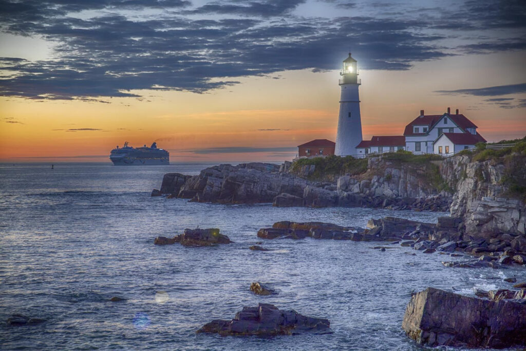 Faro su una costa rocciosa con una nave da crociera sullo sfondo Faro su una costa rocciosa con una nave da crociera sullo sfondo