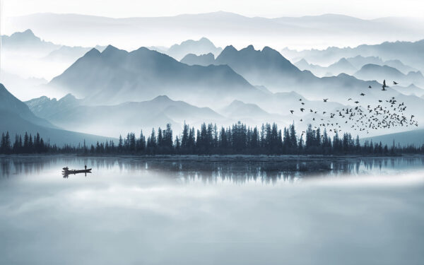 Person in a boat on a lake with mountains in the background Person in a boat on a lake with mountains in the background