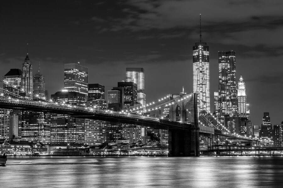 Ponte sull'acqua con skyline della città di notte