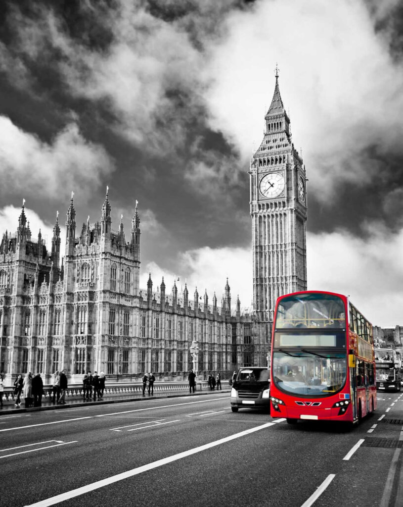 Autobus rosso a due piani su una strada con una torre dell'orologio sullo sfondo Autobus rosso a due piani su una strada con una torre dell'orologio sullo sfondo