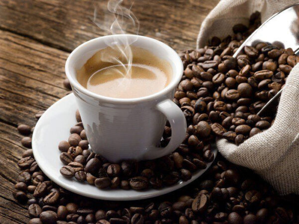 Tazza di caffè su piattino con chicchi di caffè Tazza di caffè su piattino con chicchi di caffè