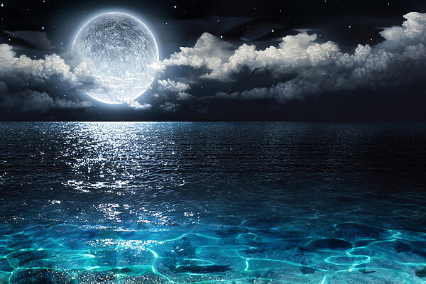 A moon over water at night