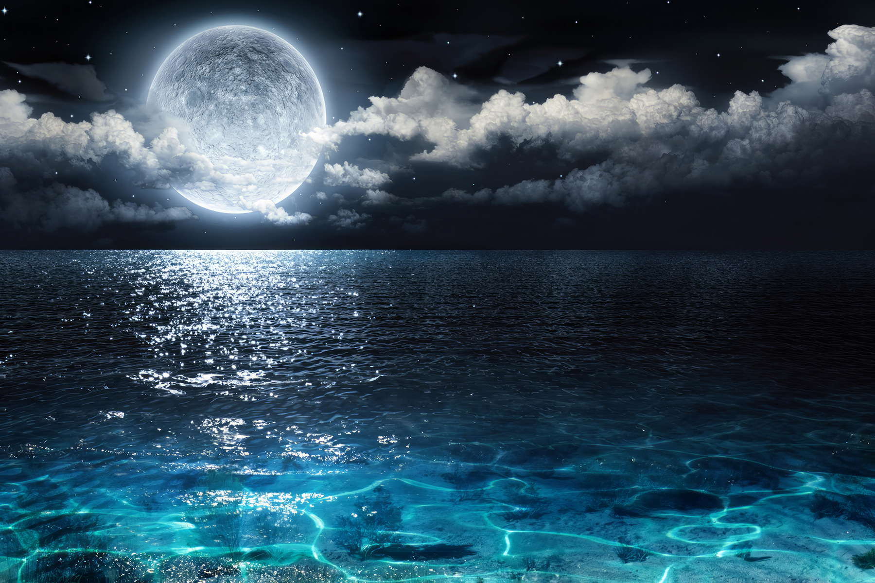 A moon over water at night