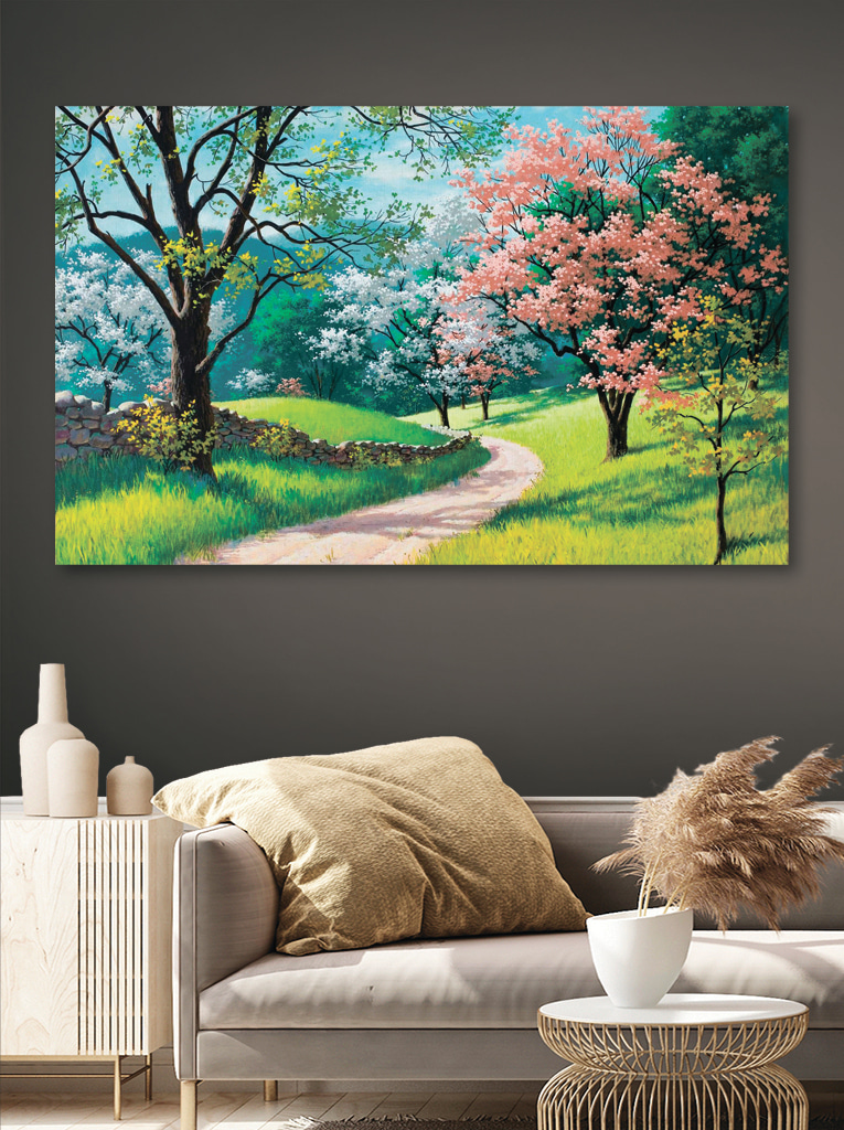A dirt road through a grassy field with trees and a stone wall