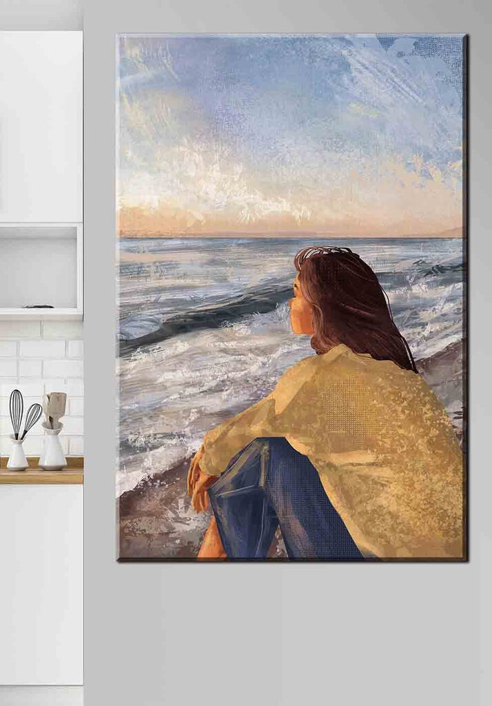 A woman sitting on a beach looking out to the ocean