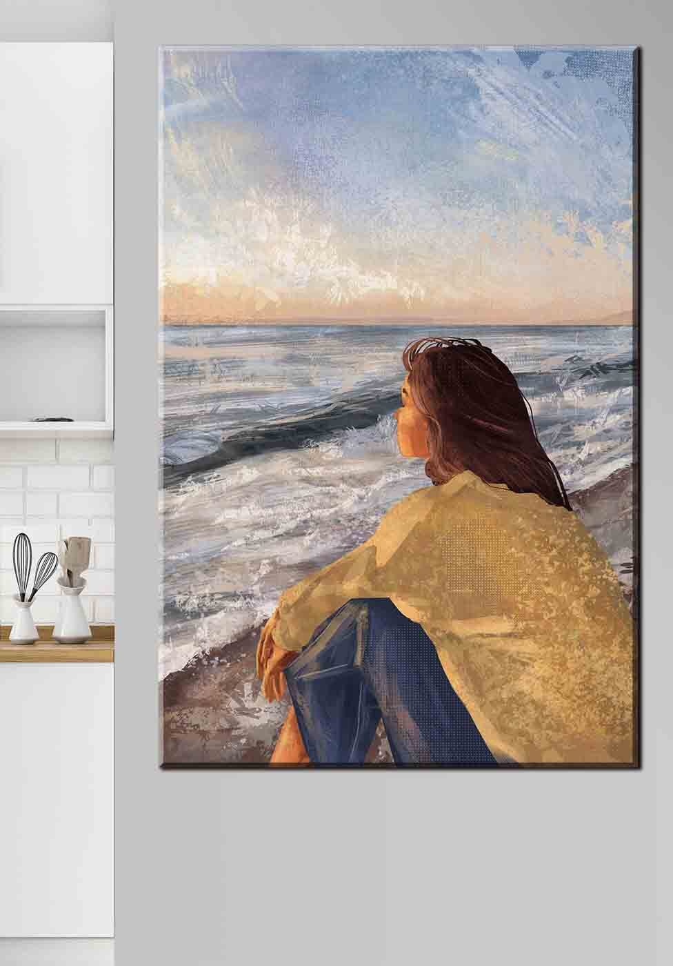 A woman sitting on a beach looking out to the ocean