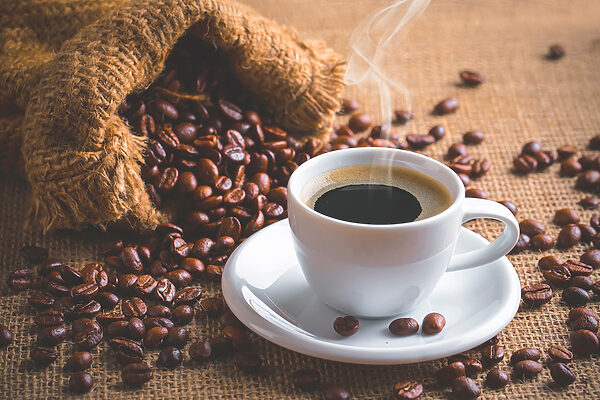 A cup of coffee and a bag of coffee beans