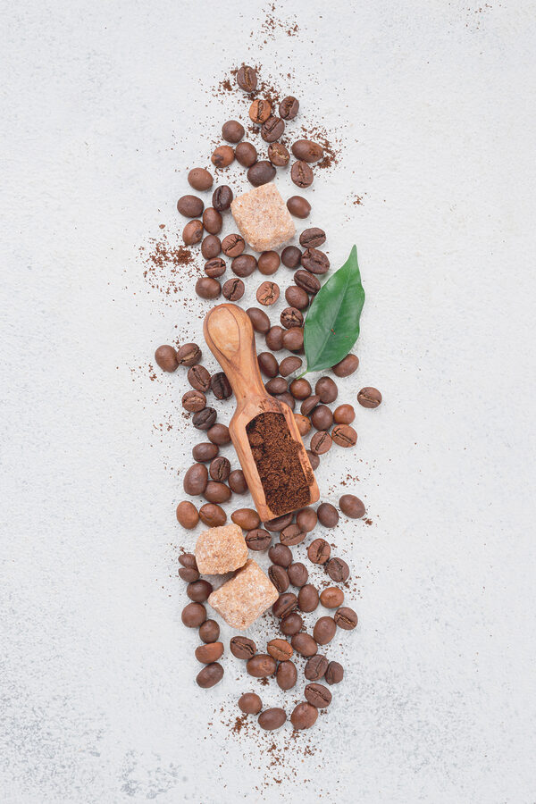 A spoon with coffee beans and sugar on top