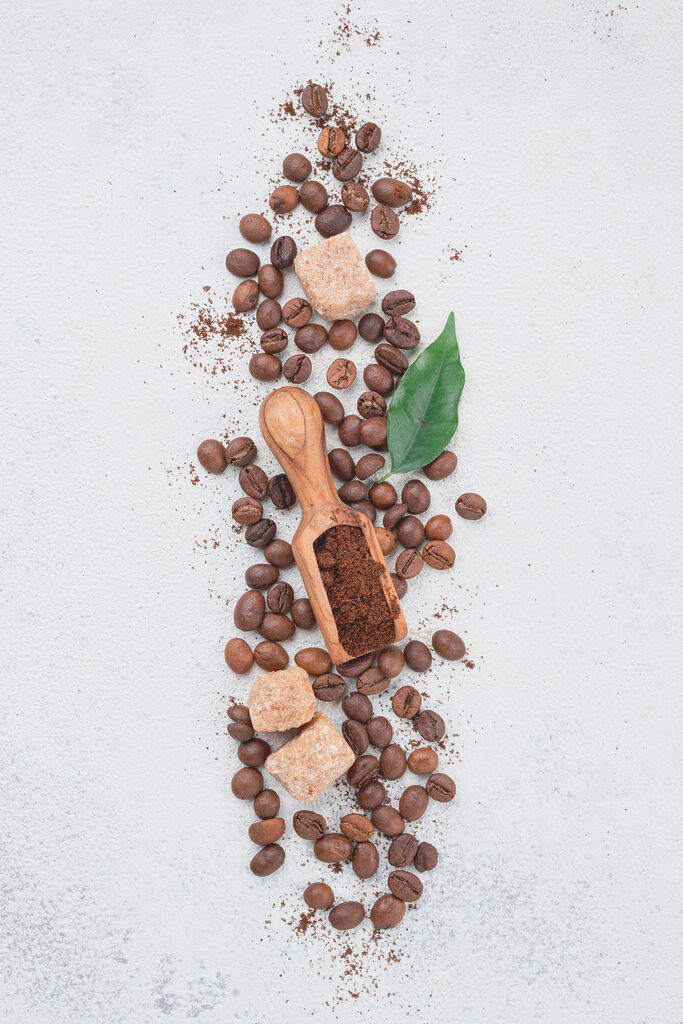 A spoon with coffee beans and sugar on top