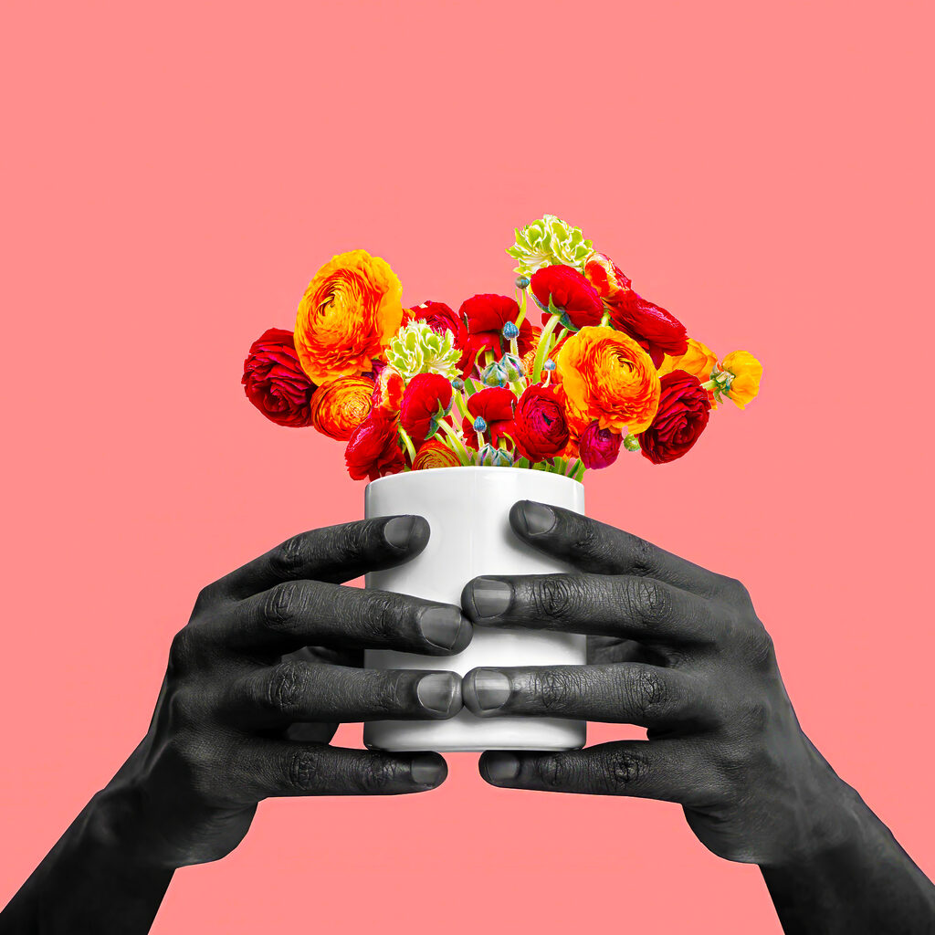 A black hands holding a white cup with flowers A black hands holding a white cup with flowers