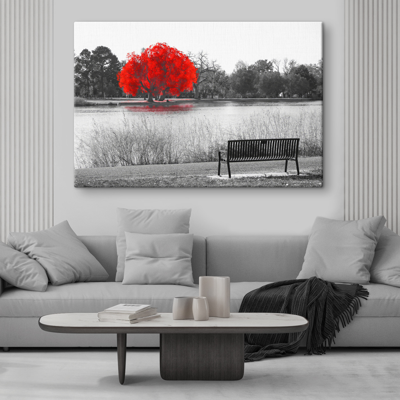 A bench by a lake with a red tree