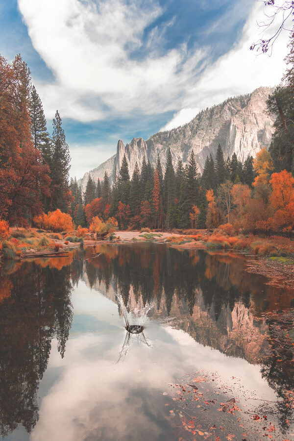 A lake surrounded by trees and mountains A lake surrounded by trees and mountains