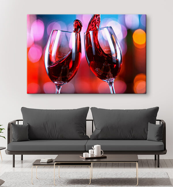 A couple of wine glasses with red liquid pouring into them