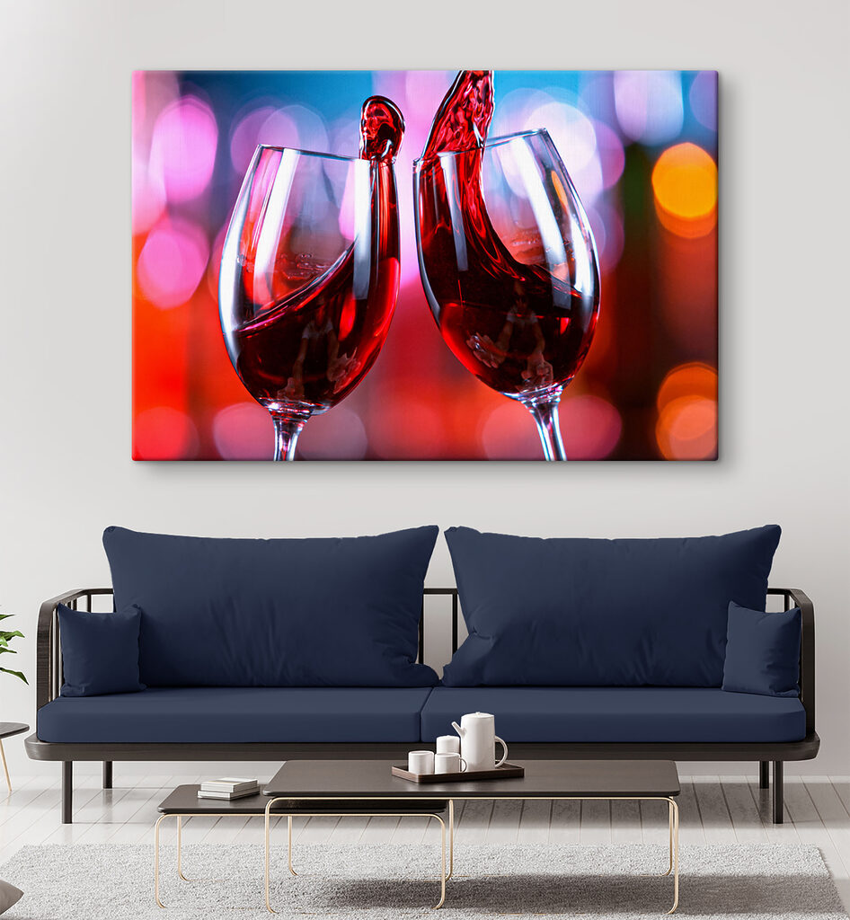 A couple of wine glasses with red liquid pouring into them