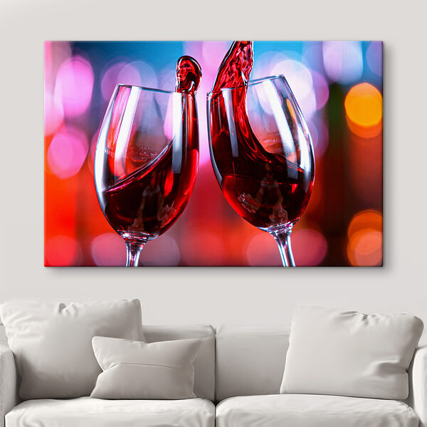 A couple of wine glasses with red liquid pouring into them