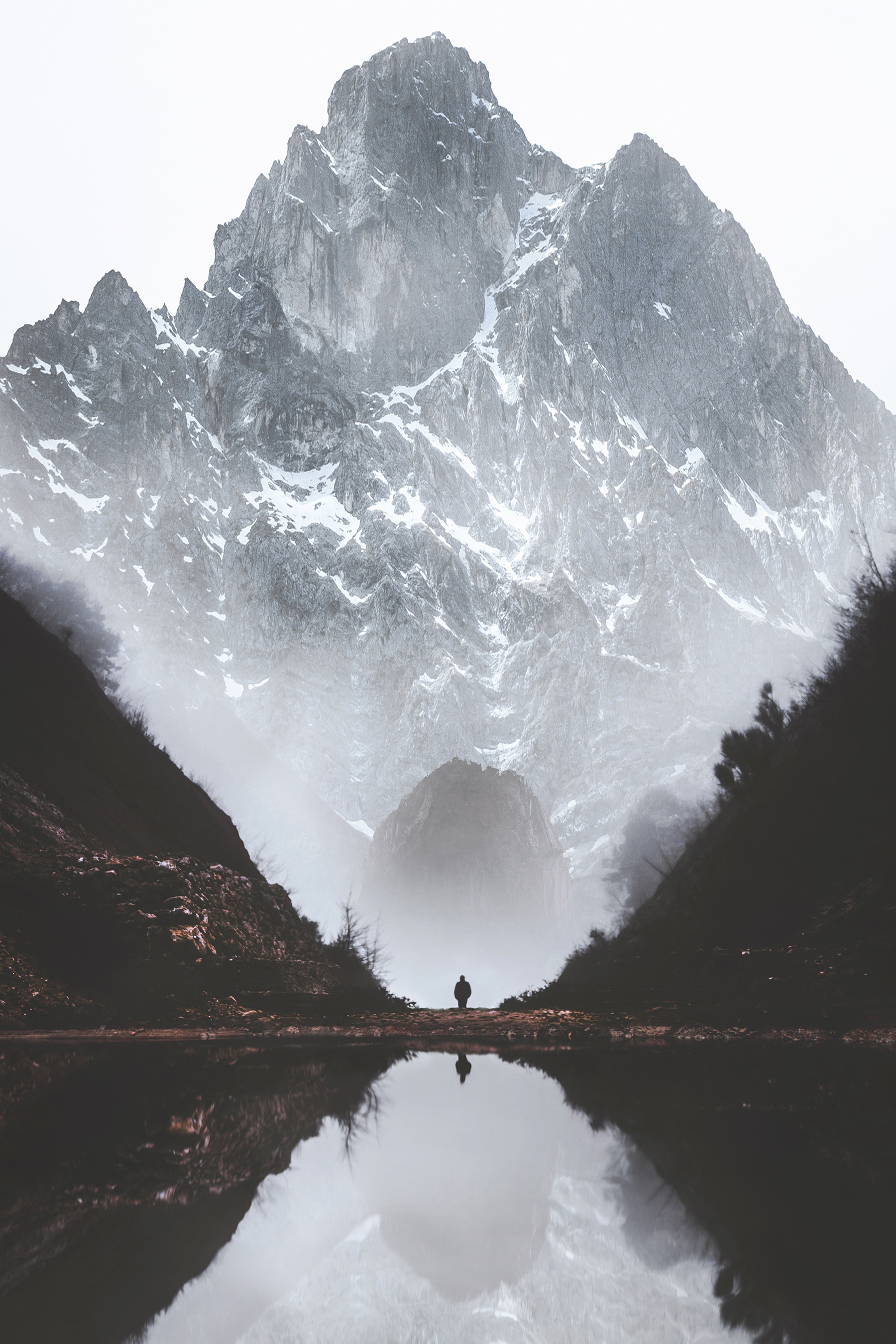 A person standing in a valley with a mountain in the background A person standing in a valley with a mountain in the background