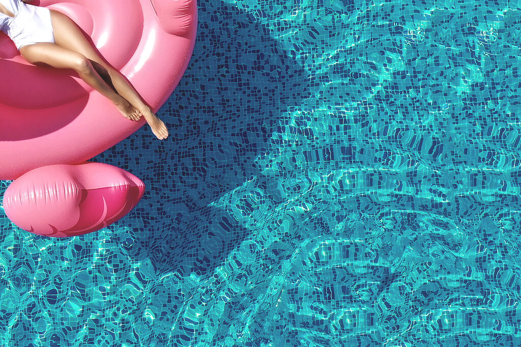 A woman on a pink float in a pool A woman on a pink float in a pool