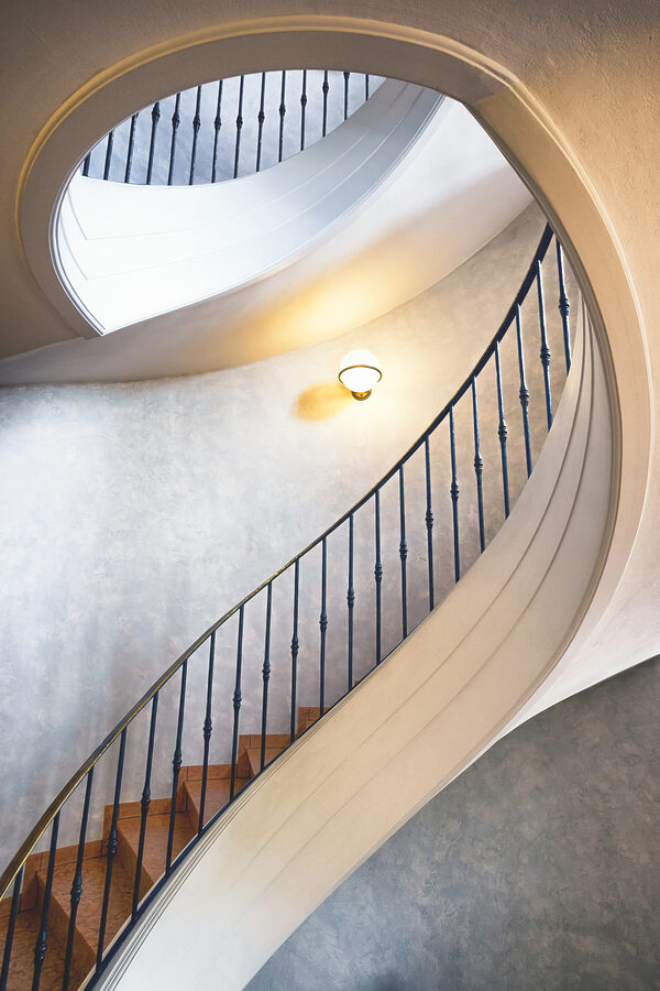 A spiral staircase with a black railing A spiral staircase with a black railing