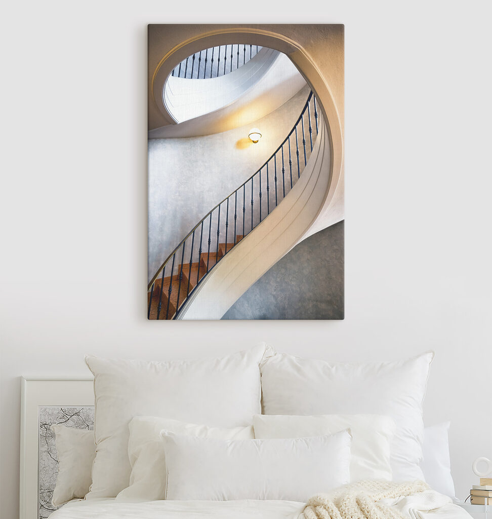 A spiral staircase with a black railing A spiral staircase with a black railing