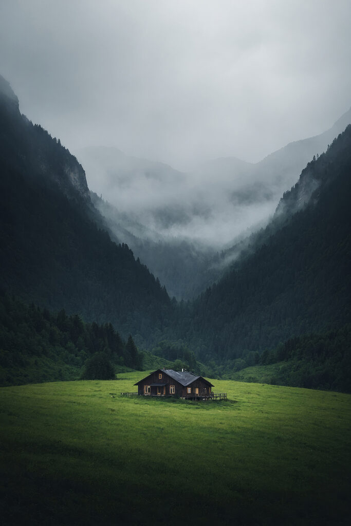 House in a field with mountains in the background House in a field with mountains in the background