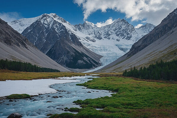 River running through a valley with snow covered mountains River running through a valley with snow covered mountains