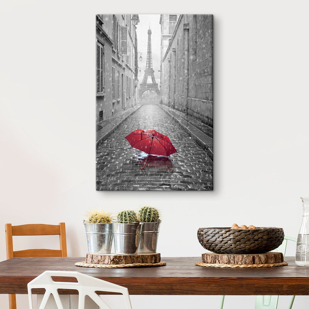 A red umbrella in a street with a tower in the background