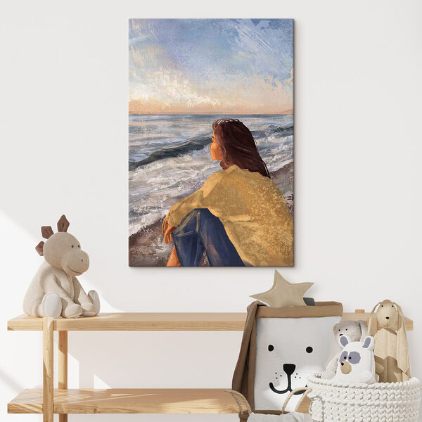 A woman sitting on a beach looking out to the ocean