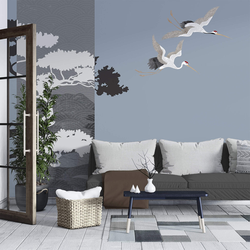 Coppia di gru in volo accanto a un albero