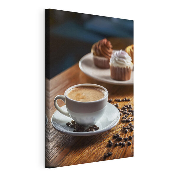 Una tazza di caffè e dei cupcake su un tavolo Quadri Una tazza di caffè e dei cupcake su un tavolo