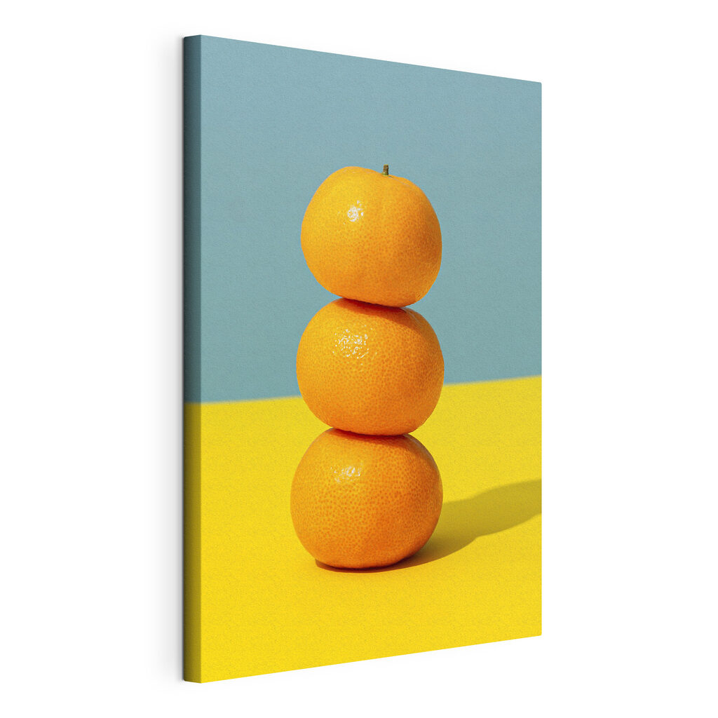 A stack of oranges on a yellow and blue surface A stack of oranges on a yellow and blue surface