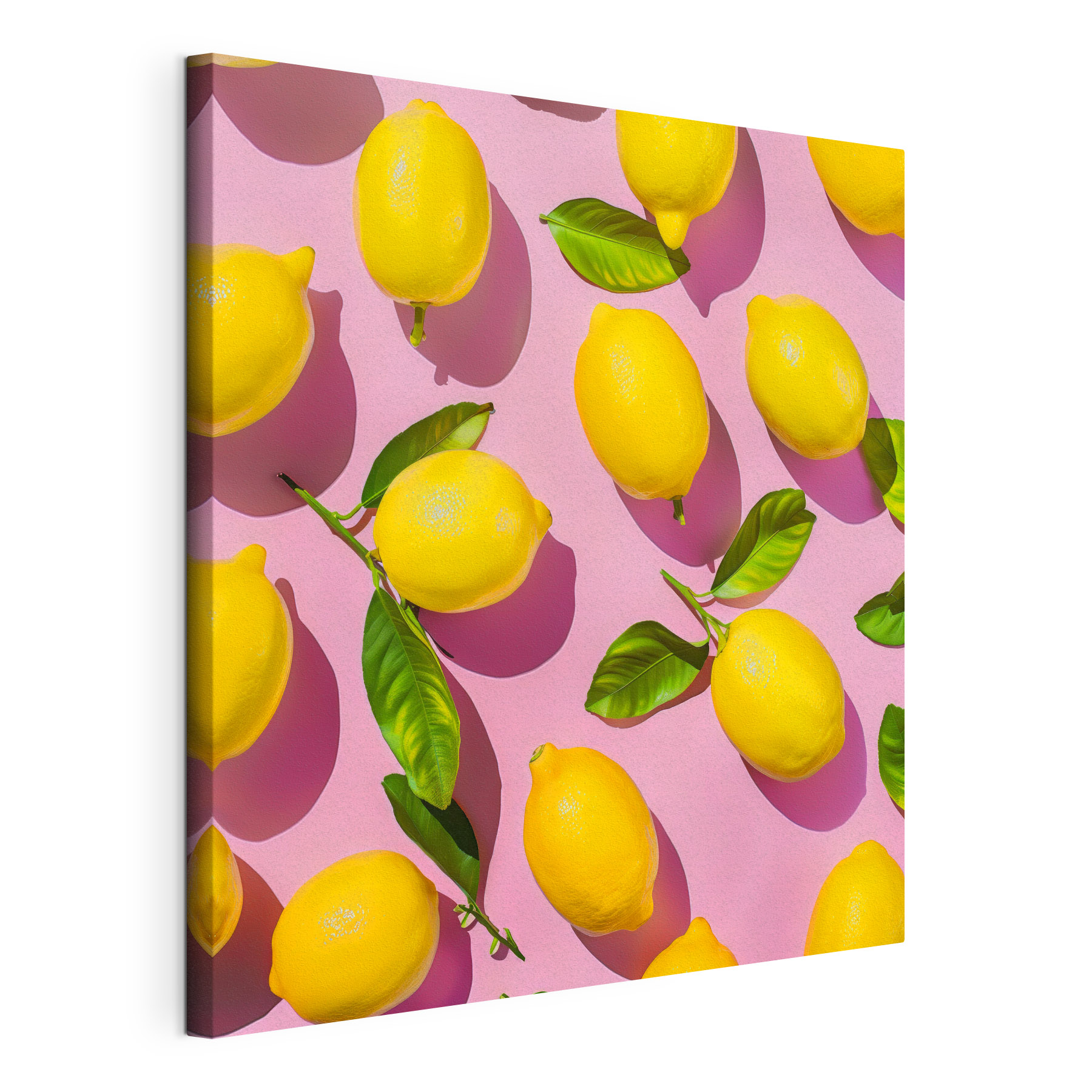 A group of lemons with leaves on a pink surface