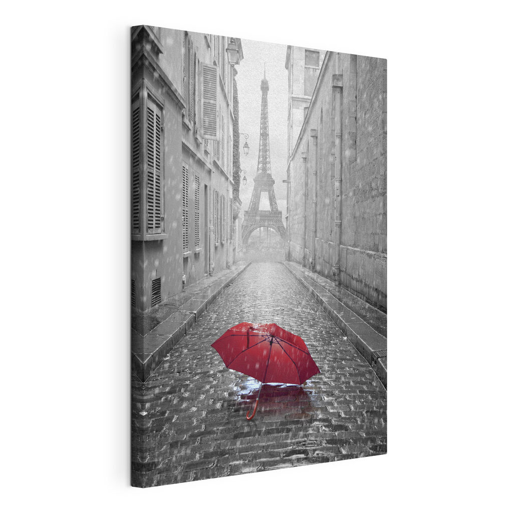 A red umbrella in a street with a tower in the background